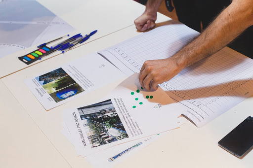 A person adding sticky dots to a worksheet as part of a workshop activity